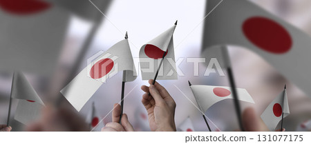Japan flags in their hands on a blurred urban background Japan flags in their hands on a blurred urban background 131077175