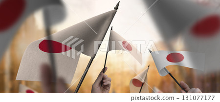 Japan flags in their hands on a blurred urban background 131077177