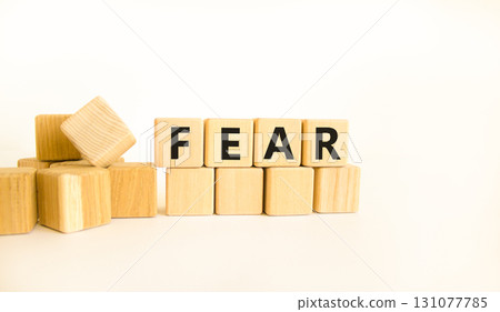 Fear symbol. Concept word Fear on beautiful wooden blocks. Beautiful white table white background. Business, lifestyle and fear concept. Copy space. 131077785
