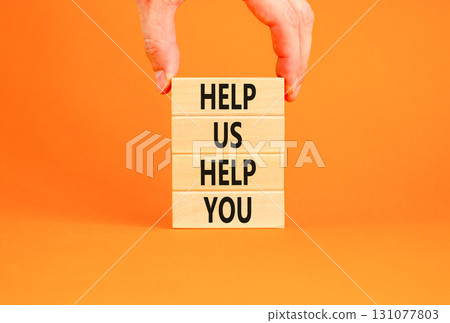 Help you symbol. Concept words phrase Help us help you on beautiful wooden blocks. Beautiful orange paper background. Businessman's hand. Business Help you concept. Copy space. 131077803