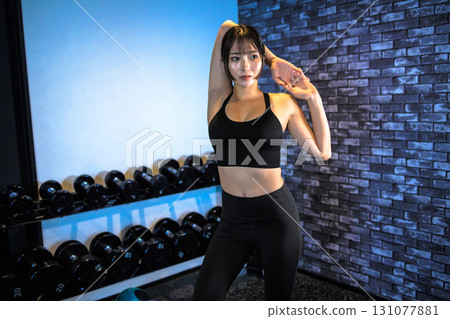 Posing well-trained woman, cool woman exercising at the gym, stretching, muscle training girl Posing well-trained woman, cool woman exercising at the gym, stretching, muscle training girl 131077881