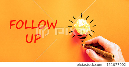 Follow up symbol. Concept word Follow up on beautiful orange paper. Businessman's hand. Light bulb icon. Beautiful orange paper background. Business follow up concept. Copy space. Follow up symbol. Concept word Follow up on beautiful orange paper. Businessman's hand. Light bulb icon. Beautiful orange paper background. Business follow up concept. Copy space. 131077902