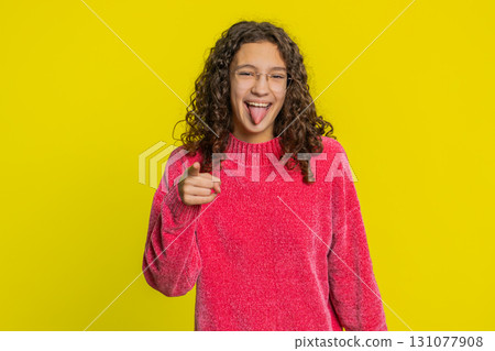 Cheerful funny bully girl showing tongue making silly faces, fooling around joking teasing 131077908