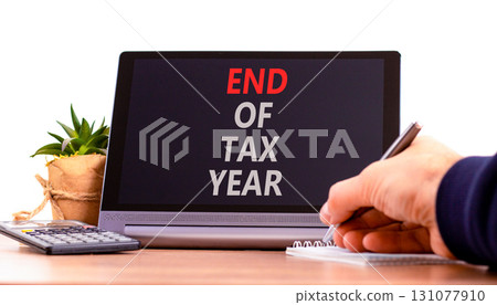 End of tax year symbol. Concept words phrase End of tax year on beautiful black tablet. Businessman's hand. Beautiful white background. Business End of tax year concept. Copy space. 131077910