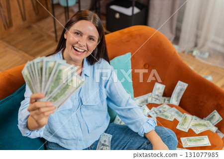 Successful happy rich business woman counting money cheering up with high profits lottery game win Successful happy rich business woman counting money cheering up with high profits lottery game win 131077985