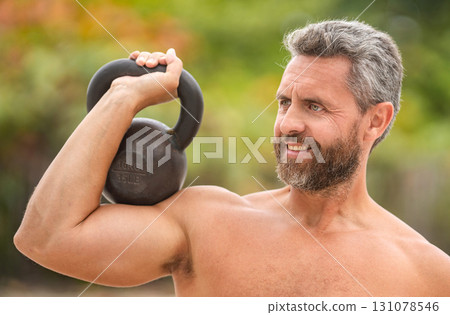 Gym workout. Sport athlete man hold kettlebell. Weightlifting kettlebell training. Mature Hispanic man exercising with kettlebell outdoor. Man athlete lifting kettlebell. Strong man do sport exercise 131078546