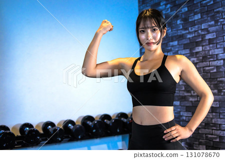 Woman flexing her bicep, cool woman exercising at the gym, upper body, muscle training, trimmed up Woman flexing her bicep, cool woman exercising at the gym, upper body, muscle training, trimmed up 131078670