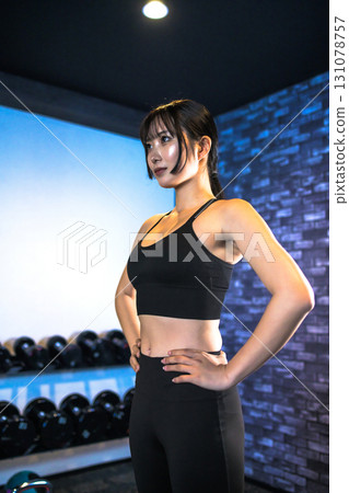 擺出訓練有素的女人，酷酷的女人在健身房鍛煉，站著擺姿勢，肌肉訓練女孩 131078757