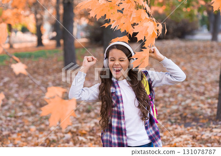happy girl wear earphones in autumn park, happiness happy girl wear earphones in autumn park, happiness 131078787