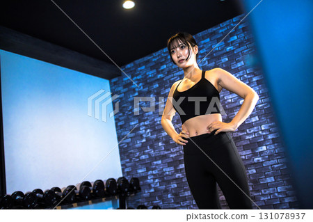 Posing well-trained woman, cool woman exercising at the gym, standing in a pose, muscle training girl 131078937
