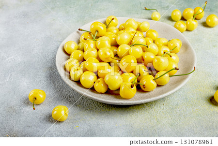 yellow cherry, cherry berry, scattered on a plate, top view, no people, 131078961