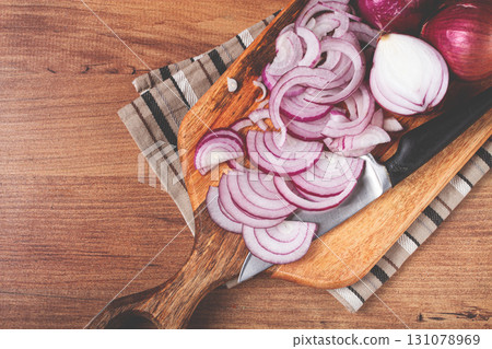 sliced red onion, on a chopping board, with a knife,Spanish onion, raw onion, close-up, top view, 131078969