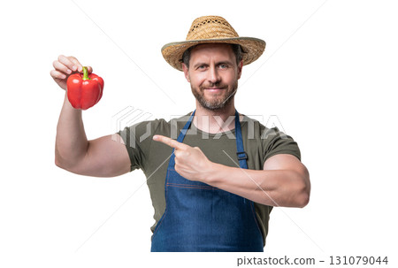 man in apron and hat with sweet pepper vegetable isolated on white. pointing finger man in apron and hat with sweet pepper vegetable isolated on white. pointing finger 131079044