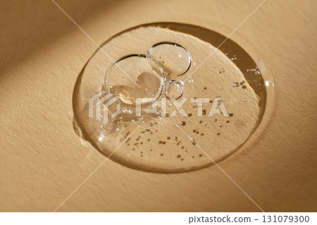A drop of serum on a beige background. 131079300