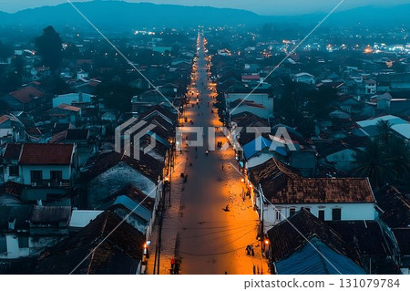 Aerial view of a street illuminated by streetlights at dusk in a Aerial view of a street illuminated by streetlights at dusk in a 131079784