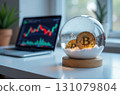 Bitcoin in a snow globe, a laptop with exchange charts on the table 131079804