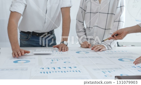 Group of business people is collaborating in modern office environment, analyzing financial data and charts, evaluating performance and developing company growth strategy 131079903