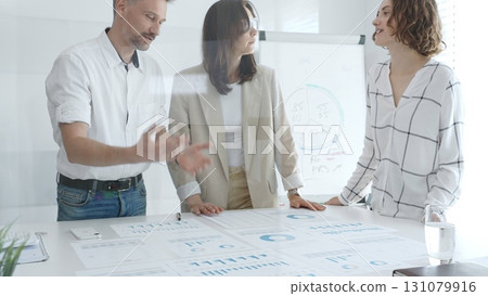 Professional team reviewing financial data, sharing success, collaborating around workplace documents, displaying corporate achievement and positive workplace dynamics. Business people concept Professional team reviewing financial data, sharing success, collaborating around workplace documents, displaying corporate achievement and positive workplace dynamics. Business people concept 131079916