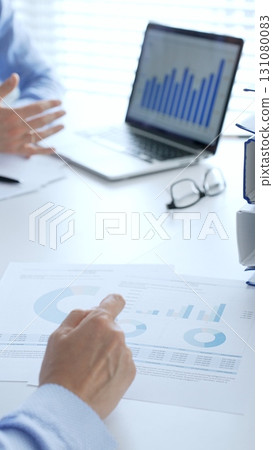 Business partners reviewing financial documents charts and diagrams , working collaboratively at white desk in office. Audit and taxes in business 131080083