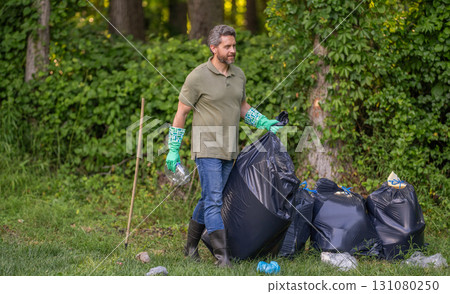 Environmental protection. Man environmental activist. Environmental conservation. Save environment. Environment plastic pollution. Volunteer man collecting garbage in forest. Copy space 131080250