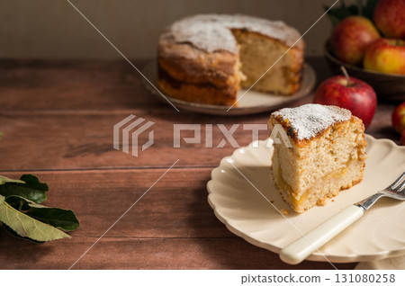Slice of homemade apple cake with cinnamon, wooden background, lifestyle, copy space 131080258