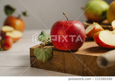 Red apple, whole and sliced on a wooden cutting board, lifestyle, top view. Autumn abstract food background. Red apple, whole and sliced on a wooden cutting board, lifestyle, top view. Autumn abstract food background. 131080260