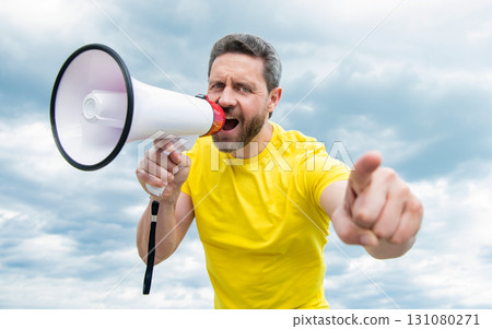 man in yellow shirt shout in loudspeaker on sky background. discount man in yellow shirt shout in loudspeaker on sky background. discount 131080271