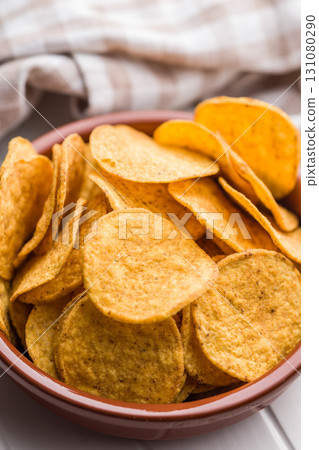 Crispy potato chips in bowl on white table. Crispy potato chips in bowl on white table. 131080290