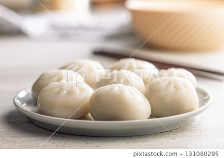 Xiao long bao. Chinese dumplings on plate on kitchen table. 131080295