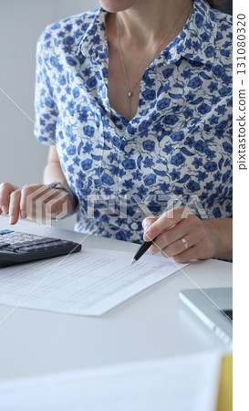 Businesswoman using calculator and filling tax form, calculating expenses and managing financial data in office. Audit and taxes in business Businesswoman using calculator and filling tax form, calculating expenses and managing financial data in office. Audit and taxes in business 131080320