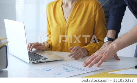 Professional team reviewing financial data on laptop, analyzing charts and strategizing corporate workflow, collaborating toward shared business objectives. Business people concept Professional team reviewing financial data on laptop, analyzing charts and strategizing corporate workflow, collaborating toward shared business objectives. Business people concept 131080352