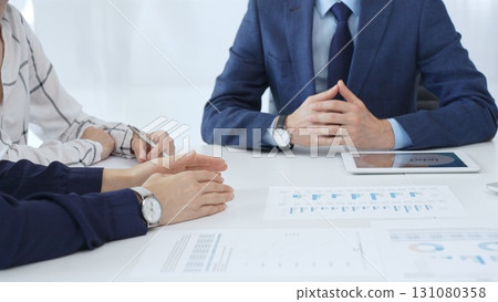 Professional team reviewing financial reports, collaborating on data analysis and strategic insights in modern corporate workspace 131080358