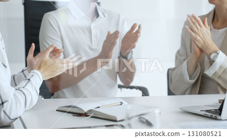 Business team applauding after achieving a goal during a productive meeting in a modern office environment, celebrating success and teamwork, close up 131080521