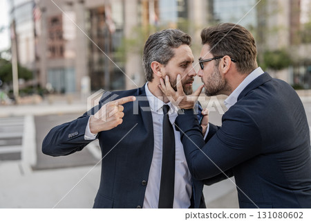 Two businessmen conflicting at fight outdoor. Businessmen having conflict in business. Conflict between boss and employee. Fight aggression. Angry businessmen. Business conflict. Angry office workers Two businessmen conflicting at fight outdoor. Businessmen having conflict in business. Conflict between boss and employee. Fight aggression. Angry businessmen. Business conflict. Angry office workers 131080602