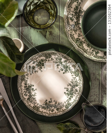 Beautiful table setting with different green rustik plates on wooden background in bright morning light. Top view 131082364