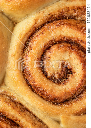 Freshly baked cinnamon roll close up top view. Making cinnamon rolls process. Cinnabon preparation Freshly baked cinnamon roll close up top view. Making cinnamon rolls process. Cinnabon preparation 131082414