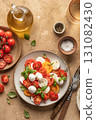 Caprese salad with sliced tomatoes, mozzarella, basil, olive oil on brown textured background. Top view 131082430