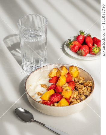 Granola or muesli with natural greek yogurt, strawberry and peach in a bowl on a white background 131082750