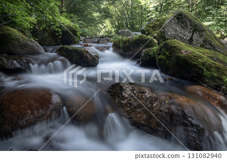 清澈的山間溪流蜿蜒流過長滿青苔的大岩石 清澈的山間溪流蜿蜒流過長滿青苔的大岩石 131082940