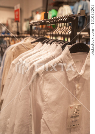 White shirts neatly displayed in retail store. Concept of formal wear, business clothing, fashion retail. 131083202