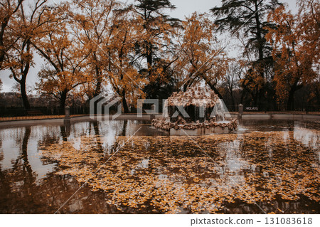 Autumnal pond scene with trees reflecting in calm water. A serene autumn lake features reflecting trees with golden leaves, a tranquil atmosphere. Autumnal pond scene with trees reflecting in calm water. A serene autumn lake features reflecting trees with golden leaves, a tranquil atmosphere. 131083618