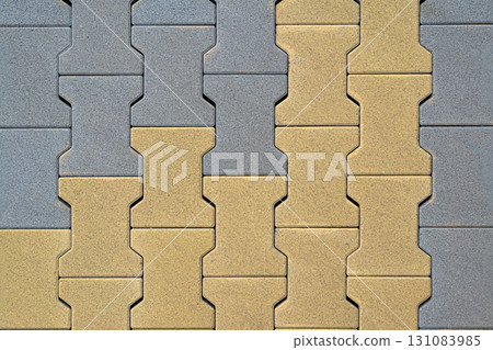 Interlocking yellow and gray paving tiles with wave shaped geometry and clean modern surface. Concept of paving tiles, natural pattern, flooring background 131083985