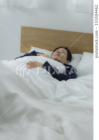 一名婦女在床上的看一個智能手機 一名婦女在床上的看一個智能手機 131084462