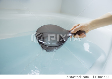 Woman's hand scooping hot water Woman's hand scooping hot water 131084482