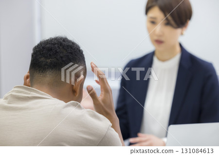 A woman explaining to a foreign man A woman explaining to a foreign man 131084613