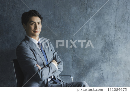 man in suit sitting on chair 131084675