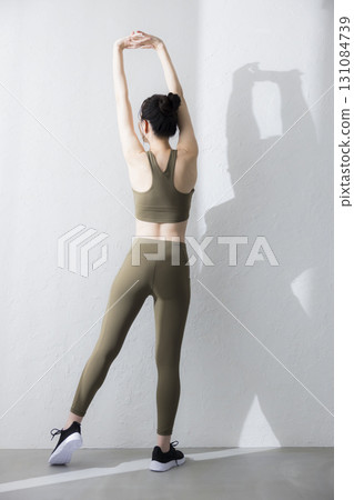 A woman stretching in training wear A woman stretching in training wear 131084739