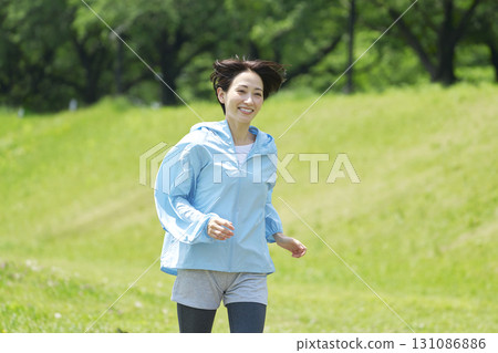 A woman in her 40s running outdoors 131086886