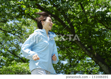 A woman in her 40s running outdoors 131086891