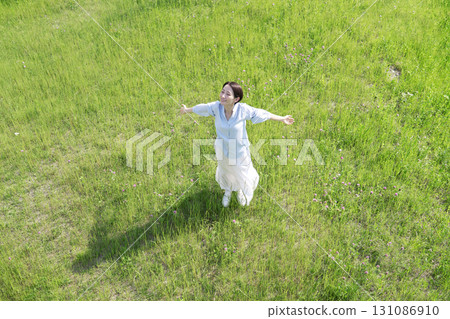 Aerial view of a woman taking a deep breath in the field 131086910